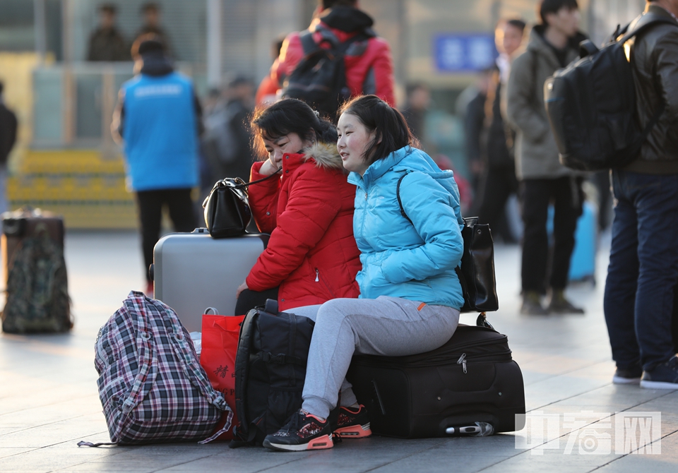 寒风中，母女依偎在一起，等待登上回家的火车。 中宏网记者 富宇 摄