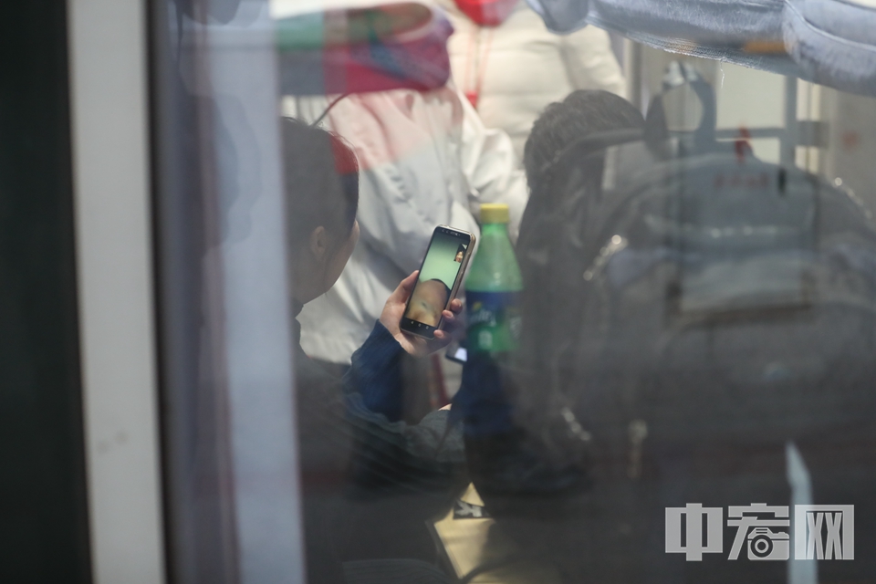 在卧铺车厢中，一位旅客使用手机与亲友视频通话。 中宏网记者 富宇 摄
