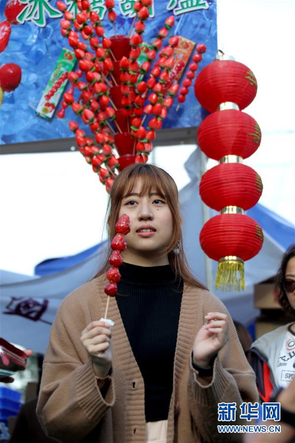2月2日，年轻人在香港维多利亚公园年宵花市参观。临近春节，香港各大年宵花市一日比一日红火，人们纷至沓来，赏花购物。新华社记者 吴晓初 摄