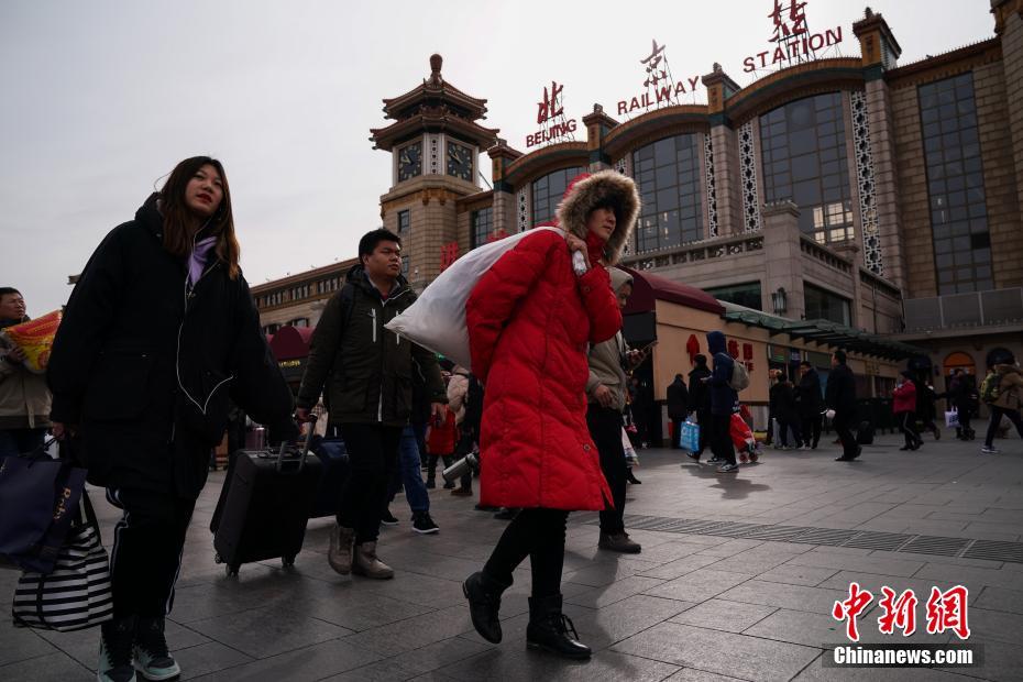 图为旅客们走过北京站前。中新社记者 崔楠 摄