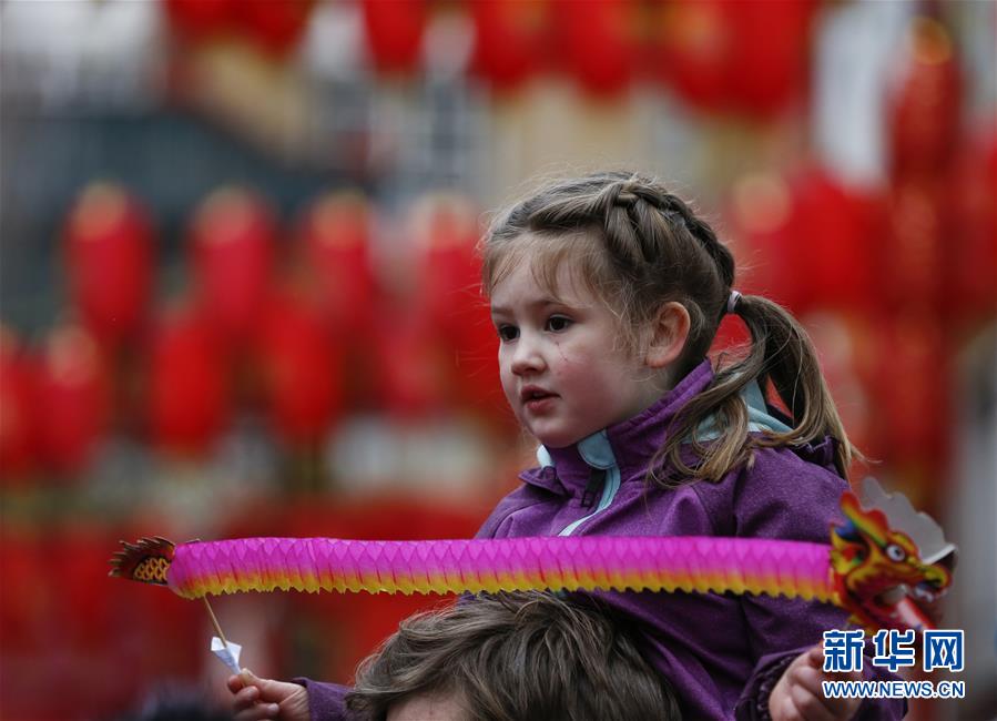 　2月10日，在英国伦敦，一名小女孩观看新春巡游。 当日，伦敦举行新春巡游，舞龙、舞狮表演队等从特拉法加广场出发，一路行进至中国城，沿途与观众互动，共同庆祝中国农历新年。 新华社记者韩岩摄