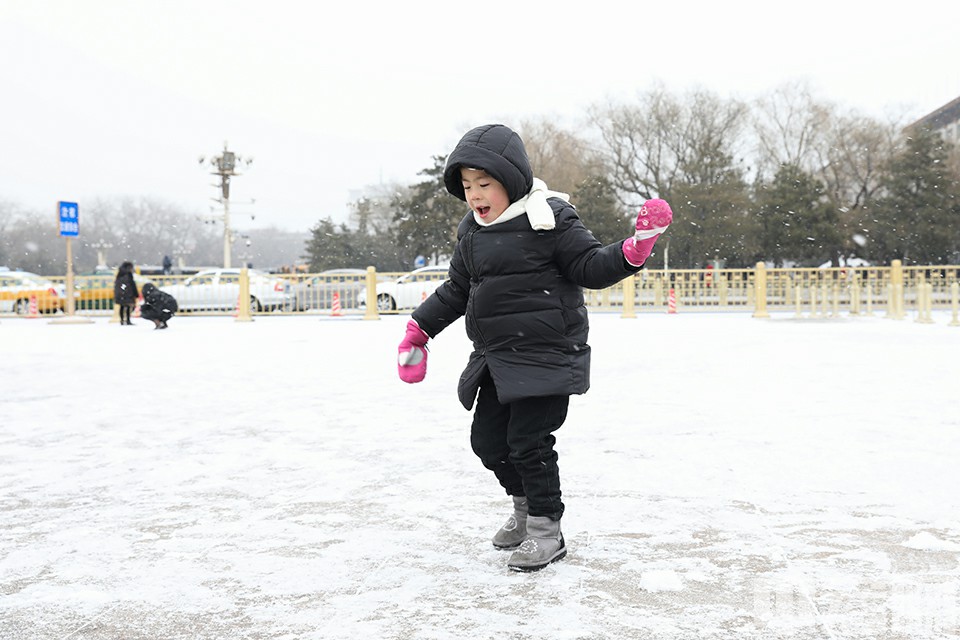 小朋友欢乐地在天安门广场上玩雪。中宏网记者 富宇 摄