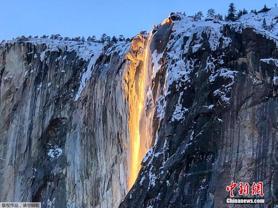 当地时间2月18日，位于美国加州约塞米特国家公园的马蹄铁瀑布在阳光下倾泻而下，远远望去被阳光映红的水流化作一条“火瀑布”悬挂山间。 图片来源：中新网