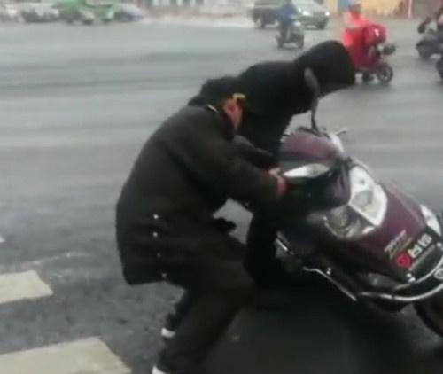 2月20日，河南郑州街头，路人和电动车纷纷在一段道路上摔倒，不少电动车还往前滑出好几米远。