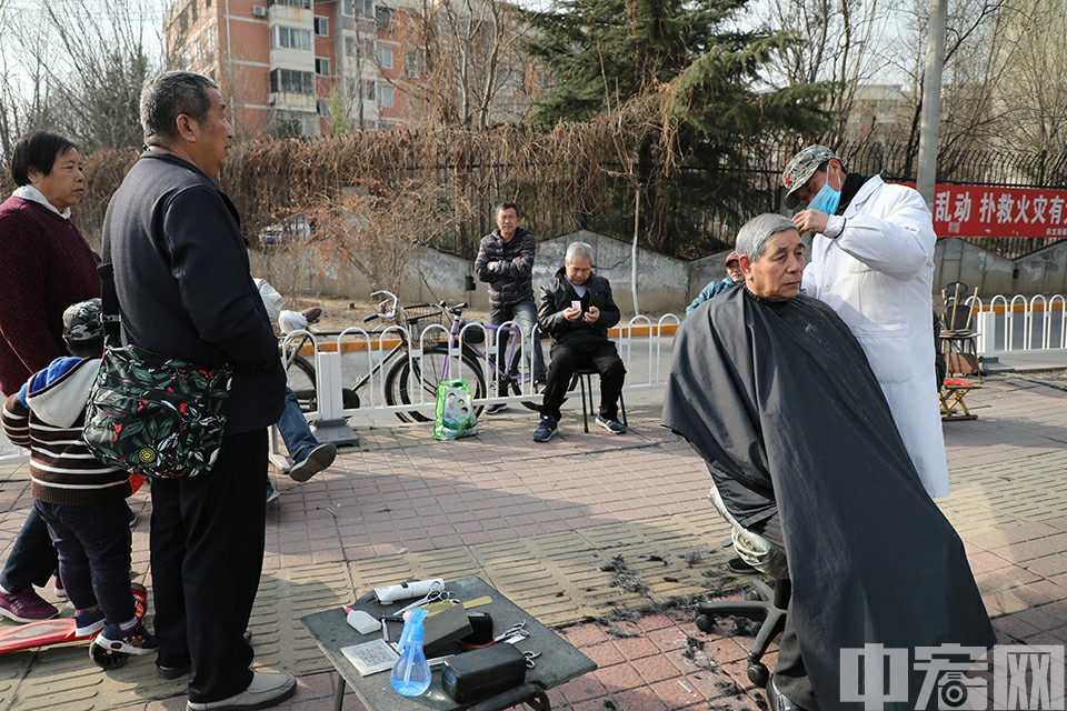 回龙观社区内，一位居民正在理发摊位“剃龙头”。中宏网记者 康书源 摄