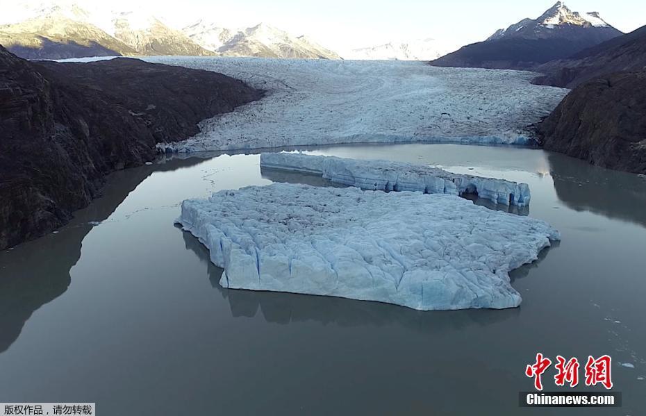 近日，智利巴塔哥尼亚的格雷冰川发生断裂，两座冰山从冰川上脱落后漂浮在湖中。 图片来源：中新网
