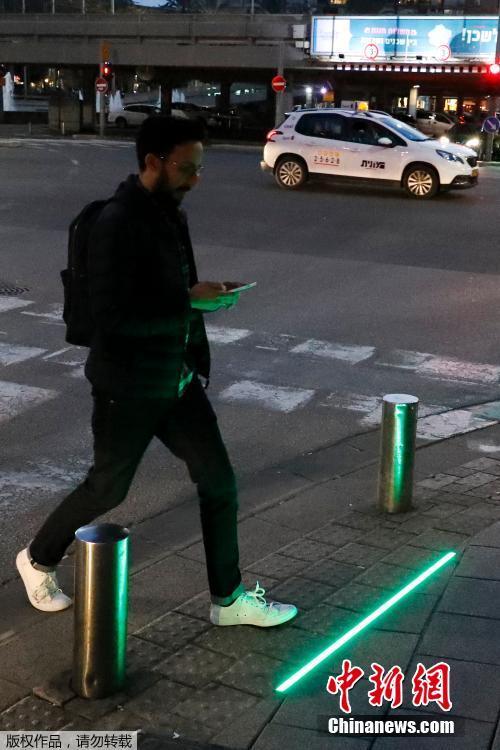 当地时间3月12日，以色列特拉维夫沿海地区街道出现了一批安装在地面的LED交通信号灯。这些信号灯是专为走路玩手机的“低头族”准备的，用以防止发生交通意外。 图片来源：中新网