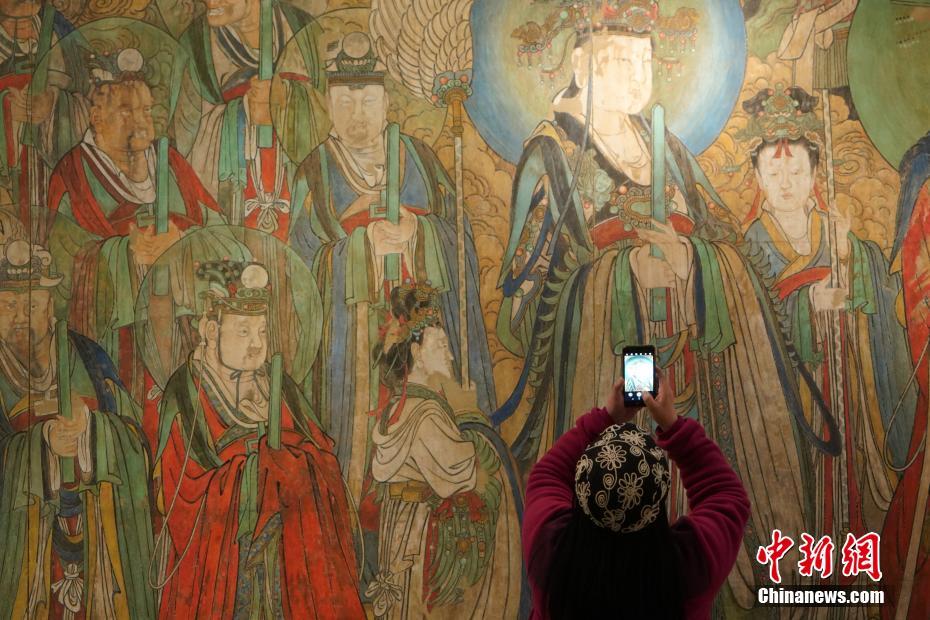 3月17日，《“千年壁画、百年沧桑——古代壁画暨流失海外珍贵壁画再现传播与展示”巡回展览》在北京中华世纪坛圆满落幕。展览共展出130余件壁画作品。图为观众在展品前拍照。 中新社记者 张兴龙 摄