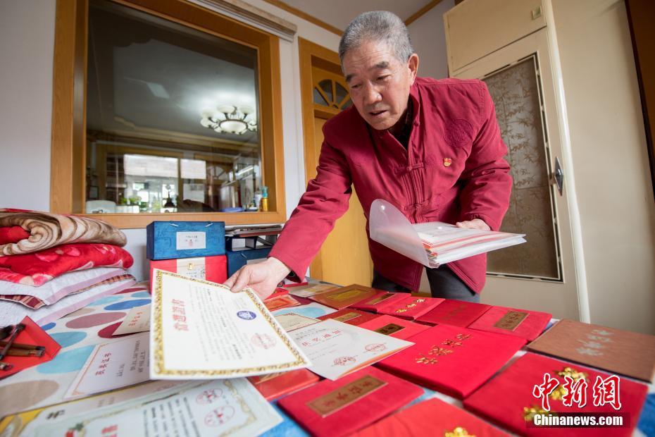 图为3月13日，山西省高平市，张喜才老人在家中展示他各类获奖证书。 中新社记者 韦亮 摄