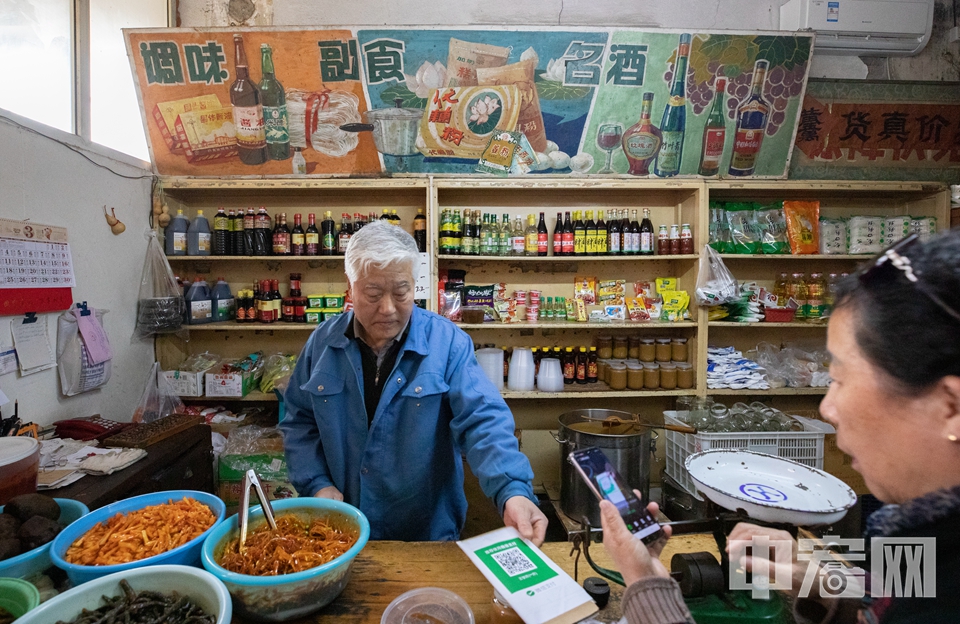 李师傅为顾客出示微信收款码，成为老副食店与时俱进的一景。 中宏网记者 富宇 摄