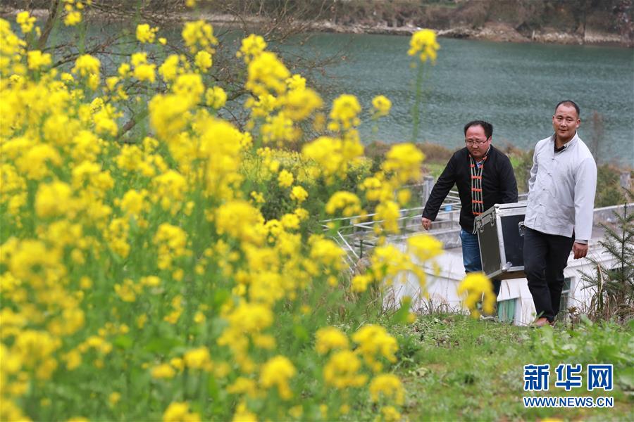 3月19日，在天柱县坌处镇三门塘村，黄宜印（左）与助手王扬清搬运电影播放设备。  新华社记者欧东衢摄