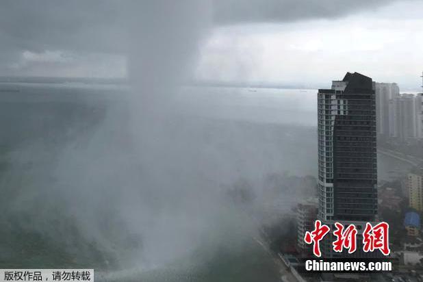 当地时间4月1日，马来西亚槟城出现了一个水龙卷，岸边的高楼面对巨大的水龙卷显得格外“矮小”。 图片来源：中新网