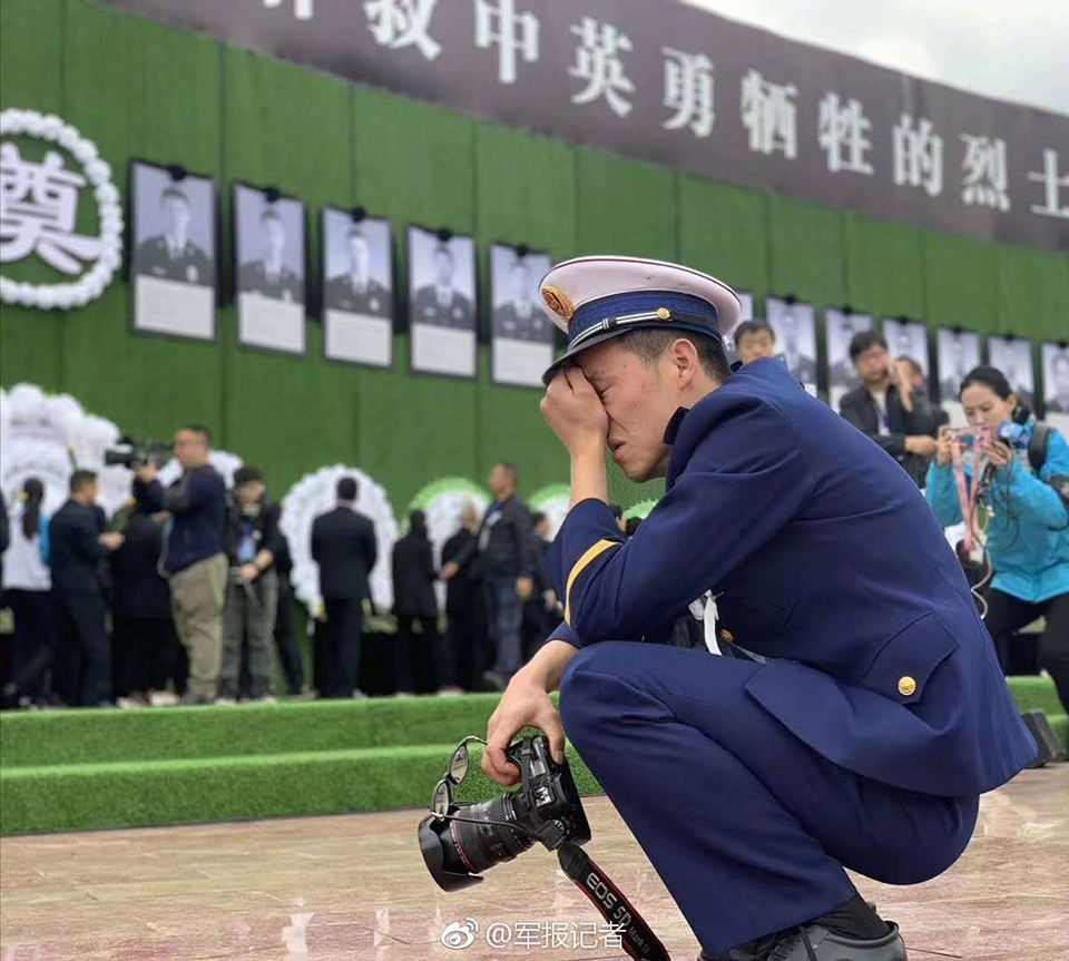 4月4日上午，悼念四川木里森林火灾扑救中英勇牺牲烈士活动举行。在追悼会现场，一名消防员放下手中的相机，蹲下身掩面哭泣。 图片来源：中国军网微博