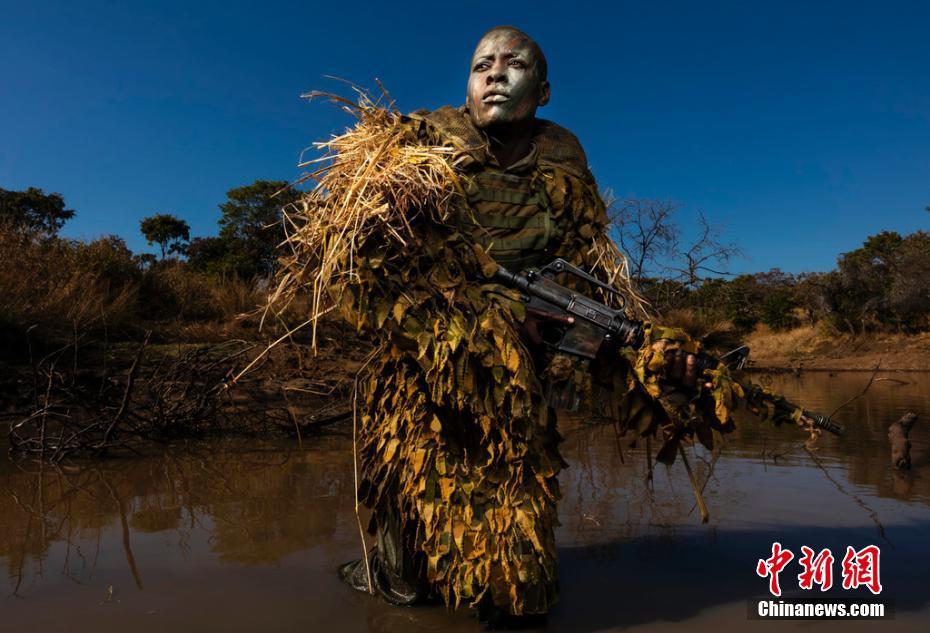 环境类单幅一等奖：阿卡辛加-勇敢者<br/>
Brent Stirton 摄<br/>
津巴布韦Phundundu野生公园，非洲女性武装反偷猎组织阿卡辛加（Akashinga）的成员Petronella Chigumbura参加隐蔽伪装训练。