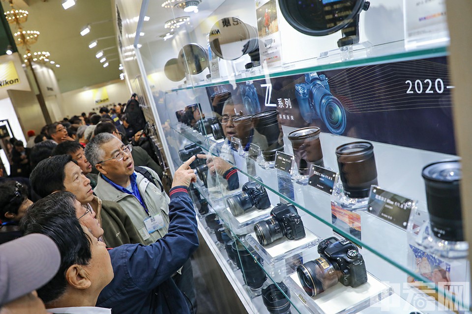 4月12日，北京展览馆，观众在尼康展示区谈论商品。中宏网记者 康书源 摄