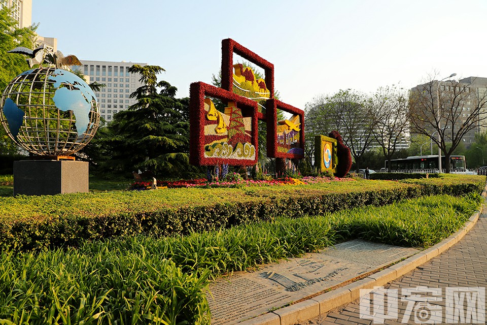 第二届一带一路国际合作高峰论坛即将在北京举办。花坛景观为，一只大手举着手机，旁边有象征画框的三个花草制作的图案，寓意一带一路沿线的风景。中宏网记者 康书源 摄