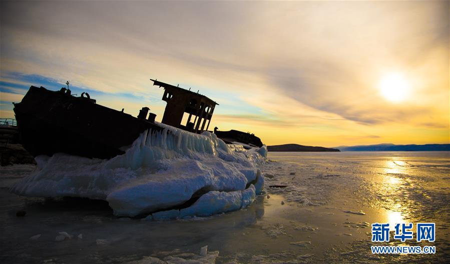 在俄罗斯贝加尔湖奥利洪岛上拍摄的日落时分的废船。 新华社记者张帆摄
