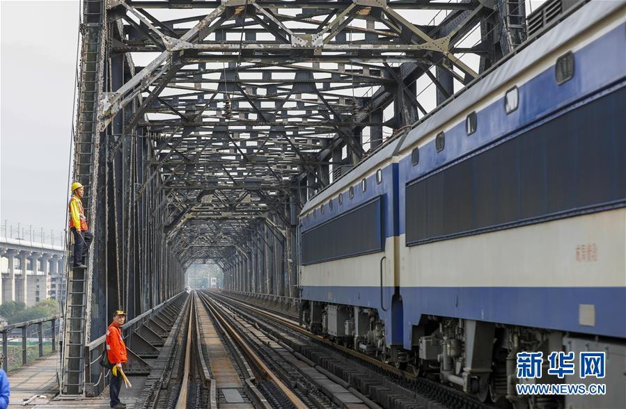 中国铁路成都局有限公司重庆工务段的巡检班组在白沙沱长江大桥上等待机车通过后继续作业（4月23日摄）。 4月23日下午5点40分，随着重庆白沙沱长江大桥通行的最后一列客运列车顺利通过，这座“服役”了59年的重庆首座长江大桥进入“退役”倒计时。4月24日后，所有列车将改线经距白沙沱长江大桥约100米的新白沙沱长江特大桥通行，新桥“接力”老桥，运输能力将得到大幅提升。 白沙沱长江大桥于1958年开工，1960年通过首趟列车，是继武汉长江大桥之后的第二座长江大桥。 新华社记者 刘潺 摄
