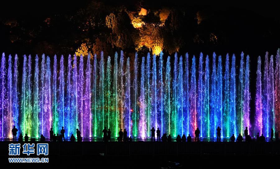 5月14日，游客在奥林匹克森林公园观看水幕灯光秀。 当晚，一场“空间光影秀”在北京上演。 新华社记者 鞠焕宗 摄