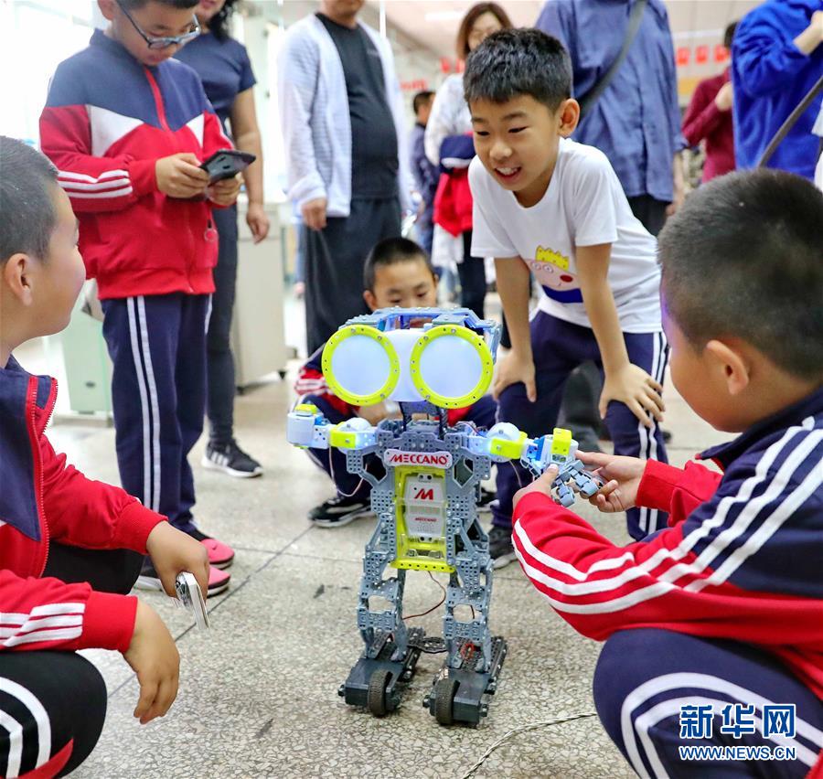 5月19日，小朋友在位于河北省秦皇岛市的燕山大学里与机器人互动。 2019年全国科技活动周于5月19日启动，各地举行了丰富多彩的活动，让人们零距离感受科技的魅力。 新华社发（曹建雄 摄）