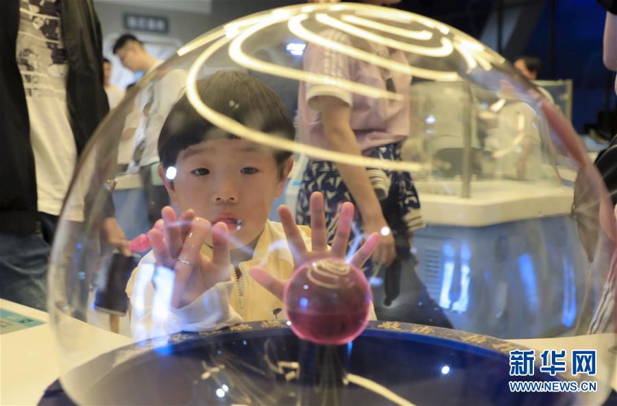 5月19日，一名小朋友在山东省滨州市科技馆体验“辉光放电”。 2019年全国科技活动周于5月19日启动，各地举行了丰富多彩的活动，让人们零距离感受科技的魅力。 新华社发（张春峰 摄）