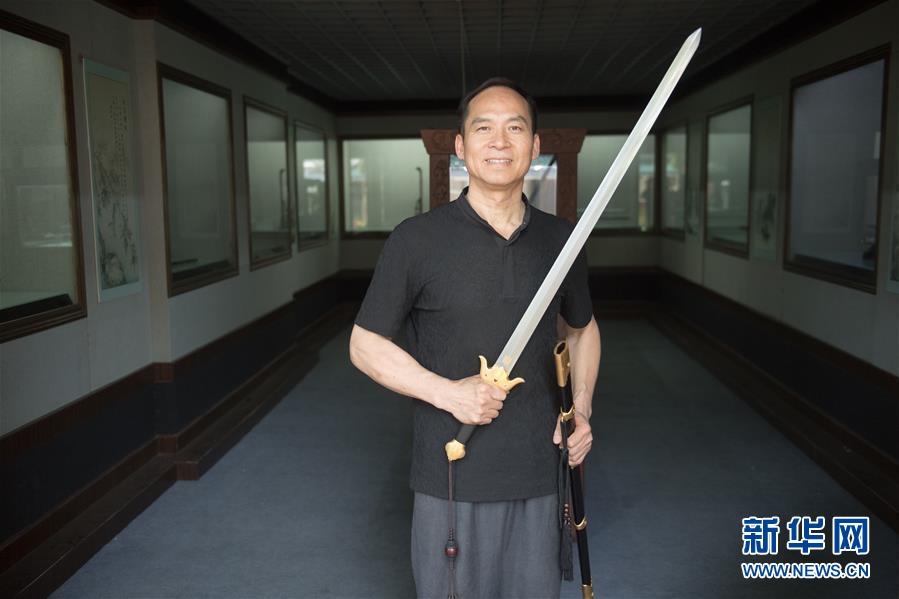 “铸剑如人生,”浙江省工艺美术大师、非物质文化遗产“龙泉宝剑锻制?#23478;鍘?#20195;表?#28304;?#25215;人郑国荣说,“从雏形到思想和意志,正是一个人成长的过程。”郑国荣1964年生于浙江龙泉,已经跟宝剑打了30多年的交道。1982年他作为学徒进入龙泉市宝剑厂,后来成立工作室“古越剑铺?#20445;?#24320;始独立的铸剑生涯。图为5月21日,郑国荣在“古越剑铺”展厅和自己铸造的一把宝剑合影。 新华社记者 翁忻旸 摄