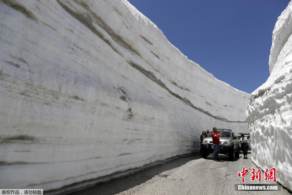 当地时间5月28日,位于黎巴嫩北部山区海拔1620米高的Ainata al-Arz村白雪皑皑,道路两旁积满厚厚的白雪,车辆在公路上行驶犹如穿行在雪谷中。 图片来源:?#34892;?#32593;