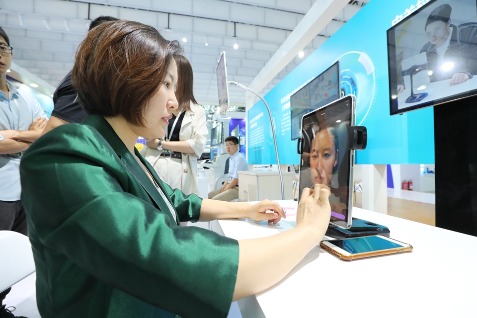 观众体验全球首款AI相貌精准诊断系统，系统通过3D人脸特征新体系及独有的识别算法，对人脸进行建模并精准识别诊断，得出颜值评测，气质定位，性格分析和科学面向分析。 中宏网记者 富宇 摄