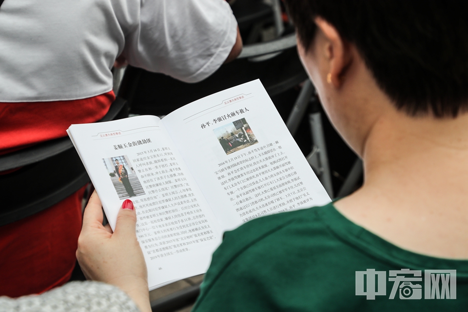 现场群众观看《北京市见义勇为宣传册》。 中宏网记者 富宇 摄