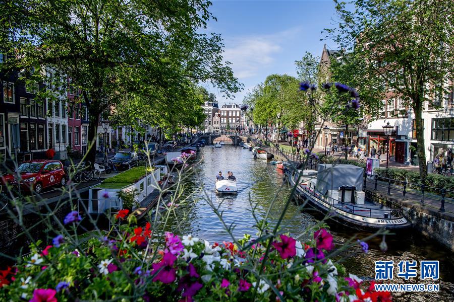 6月15日，在荷兰阿姆斯特丹，人们乘船在水道间穿梭。 通过不断更新的城镇化可持续发展战略、持续细化的政策措施和项目实施，荷兰在绿色城市建设方面取得了突出成就。荷兰多地以全面整体的方式对交通、能源、建筑、水资源和垃圾系统进行改进，进一步完善城市功能，打造绿色宜居城市。 新华社发（罗宾·乌得勒支摄）