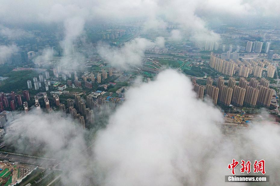 6月18日，航拍大雨暂停后的南京城区，天空雨雾缭绕。当日，江苏省淮河以南地区进入梅雨期。梅雨是每年6、7月份中国长江中下游等地区持续天阴有雨的气候现象。因恰逢梅子成熟，青梅向黄梅转变，又称“黄梅雨”。 泱波 摄 图片来源：中新网