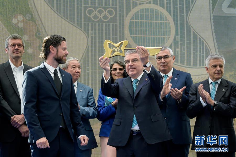 6月23日，国际奥委会主席巴赫（中）从设计师扬·阿蒙森（前左）手中接过金钥匙。<br/>

　　当日，国际奥委会新总部揭幕仪式在瑞士洛桑举行。<br/>

　　新华社/POOL/法布雷斯摄