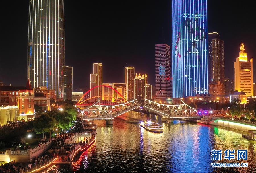 天津解放桥在7月1日晚开启（无人机拍摄）。 7月1日，位于海河之上的天津解放桥在夜色中缓缓开启桥面，周边灯火璀璨引万人围观。今后，为提升城市夜间景观效果，满足广大市民与游客的观光需求，解放桥逢重大节假日在条件允许的情况下都将进行开启。 作为天津标志性建筑物的解放桥是一座全钢结构可开启的桥梁，桥长90余米，桥面总宽近20米。解放桥原名万国桥，最初建于1902年，于1923年重建，1927年正式建成。1949年，更名为解放桥。 新华社记者李然摄