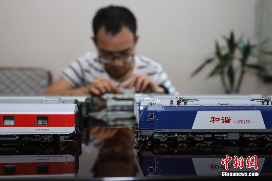 7月4日，张宇琦拼装火车模型。今年27岁的张宇琦是贵阳北动车运用所的一名动车机械师，同时他也是一个“火车迷”，从2012年开始收藏、制作各类火车模型，七年多来他已经收藏了内燃机车、电力机车等火车模型百余节。中新社记者 瞿宏伦 摄