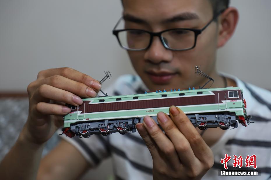 7月4日，张宇琦调节火车模型的“受电弓”。今年27岁的张宇琦是贵阳北动车运用所的一名动车机械师，同时他也是一个“火车迷”，从2012年开始收藏、制作各类火车模型，七年多来他已经收藏了内燃机车、电力机车等火车模型百余节。中新社记者 瞿宏伦 摄