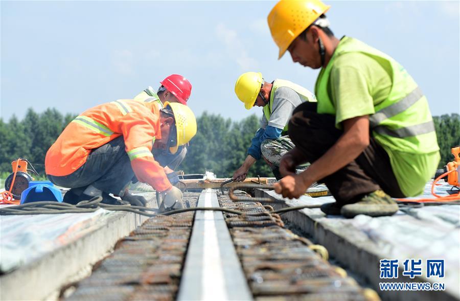 工人在京哈高速长春至拉林河段改扩建工程现场进行高速路面施工（7月9日摄）。 新华社记者 林宏 摄