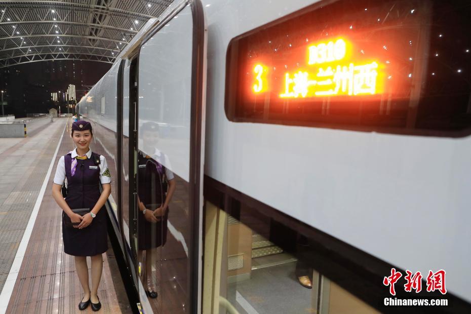 7月10日晚22:44，长三角首开“新丝绸之路”概念动卧列车上海至兰州西D310次列车从铁路上海站开出，次日中午12：51抵达兰州西站，全程运行14小时07分钟，比上海至兰州的普速列车缩短近一半时间。图为列车长迎接旅客的到来。中新社记者 殷立勤 摄