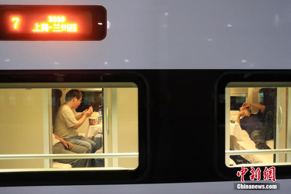 7月10日晚22:44，长三角首开“新丝绸之路”概念动卧列车上海至兰州西D310次列车从铁路上海站开出，次日中午12：51抵达兰州西站，全程运行14小时07分钟，比上海至兰州的普速列车缩短近一半时间。图为旅客乘坐上海至兰州西D310次列车前往自己的目的地。中新社记者 殷立勤 摄