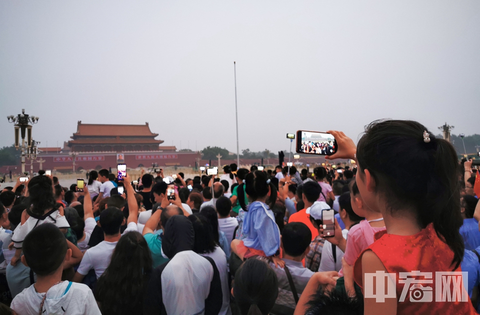 进入暑期，每天都有大批游客涌入天安门广场观看升旗仪式，人潮涌动，开启人从众模式。图为7月18日，游客在天安门广场观看升旗。 中宏网记者 富宇 摄