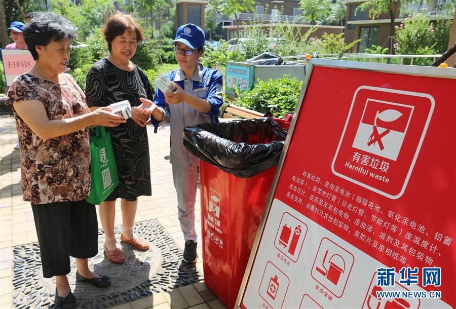 7月23日，丰台区南苑街道的居民在学习正确的垃圾分类方法。 当日，北京市丰台区南苑街道在一社区开展居民垃圾分类学习活动。社区居民在垃圾分类指导员的指导下把自家的垃圾正确分类，并投放在相应类别的垃圾桶内，同时还通过接受现场指导、观看学习展板等方式学习垃圾分类知识。 新华社记者 李欣 摄