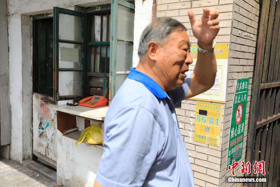 8月5日，在上海市浦东新区浦东大道2511弄门口，有一处不到3平方米的公用电话亭——一块白色小搁板从木窗户里伸出，上面是一台橙色的电话机。这是上海最后的传呼公用电话亭，88岁的吕树生在这里一坐就是25年。如今他上午8点开门，下午4点就关门了。据上海电信公司工作人员介绍，在住宅电话的普及和移动通信的发展之下，上海的传呼电话自21世纪以来开始渐渐退出市民的生活。殷立勤 摄