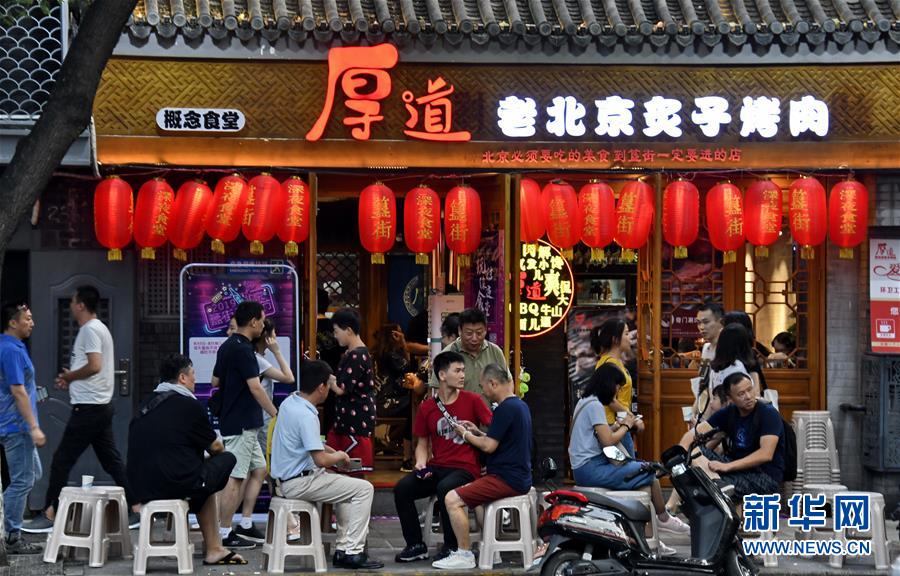 8月7日，人们在北京东城区簋街的餐饮店外等候吃夜宵。 北京市东城区依托区域内各具特色的王府井大街、南锣鼓巷、簋街等商圈，举办形式多样的“不夜节”“深夜食堂”等活动，打造大街小巷里的餐饮、夜市、旅游等夜间消费市场，满足市民和游客多元化的消费需求。 新华社记者 李欣 摄