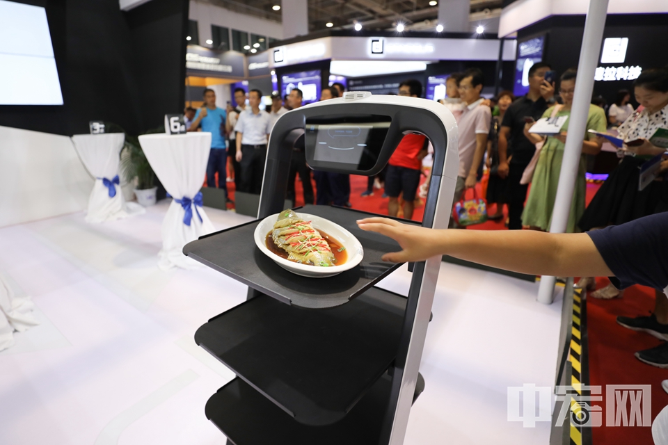 已经在许多餐厅投入使用的送餐机器人成了现场“明星”。 中宏网记者 富宇 摄