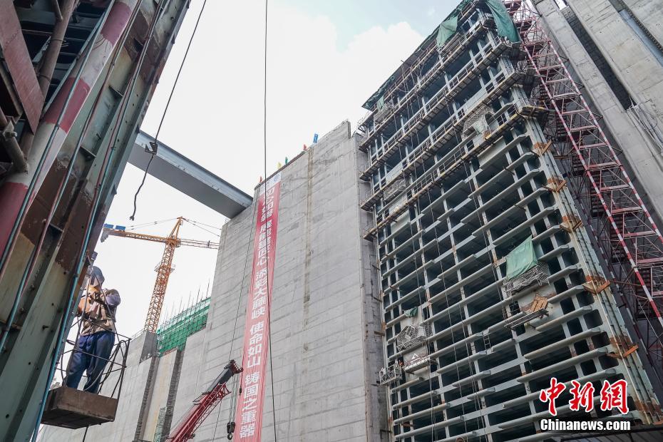 8月22日，工人在广西大藤峡水利枢纽船闸下闸首人字闸门处施工。该闸门设计高度47.5米，比三峡船闸人字闸门还高出9米，为世界最高船闸闸门，可让3000吨级船舶一次通过。大藤峡水利枢纽位于广西最大最长的峡谷——大藤峡出口处，是珠江流域关键控制性水利枢纽，被喻为珠江上的“三峡工程”。该工程建成后，西江船舶通航吨级将由当前300吨级提高至3000吨级规模，年均货运量由当前的1300万吨提高至5400万吨，成为西江亿吨黄金水道的关键节点。中新社记者 陈冠言 摄