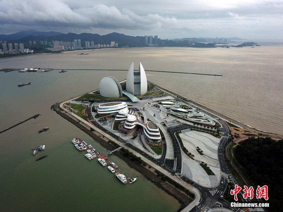 9月4日，航拍珠海大剧院。珠海大剧院坐落于珠海市情侣路野狸岛北部填海区，是中国唯一建设在海岛上的歌剧院，设计造型为“日月贝”，即一大一小的贝壳，其中大贝壳“日贝”高90米，是一个可容纳近1600人的大剧院，小贝壳“月贝”是500座的多功能厅，适合室内音乐会、小型话剧等，剧院内设有观景台，可以观山看海。中新社记者 姬东 摄