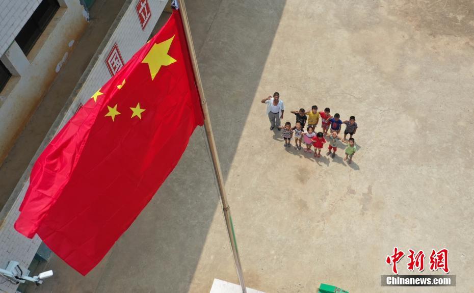 9月9日，孙玉光带着孩子们升国旗。何红福 摄