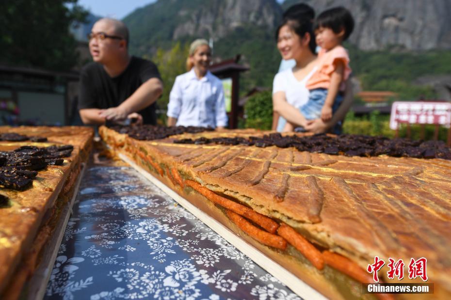 一块直径2米的巨型辣条月饼亮相湖南省平江县石牛寨，吸引众多游客与当地村民。 中新社记者 杨华峰 摄