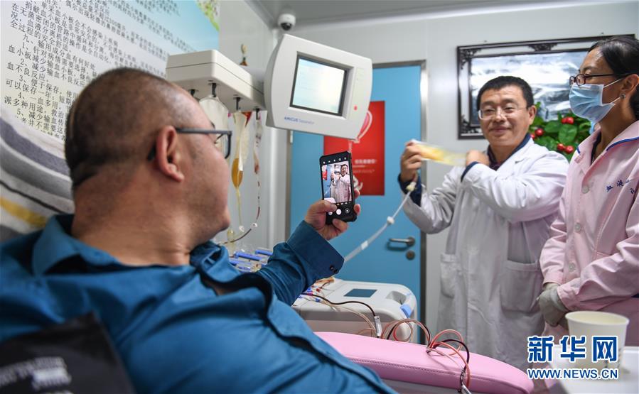 9月18日，在西藏自治区血液中心，通过机采血小板进行献血的志愿者廖志霖（左）拍照留念。新华社记者 晋美多吉 摄