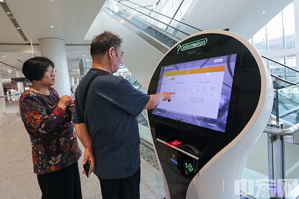 两名旅客在自助问询台查询机场信息。中宏网记者 康书源 摄