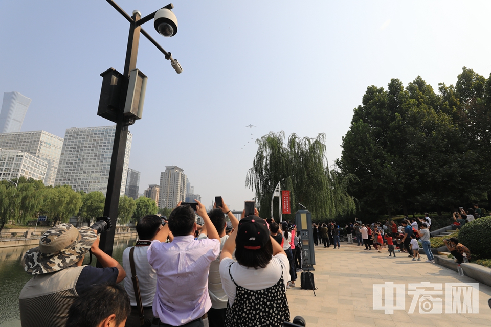10月1日上午，庆祝中华人民共和国成立70周年大会在北京天安门广场隆重举行。图为民众在公园内观看受阅空中梯队。 中宏网记者 富宇 摄